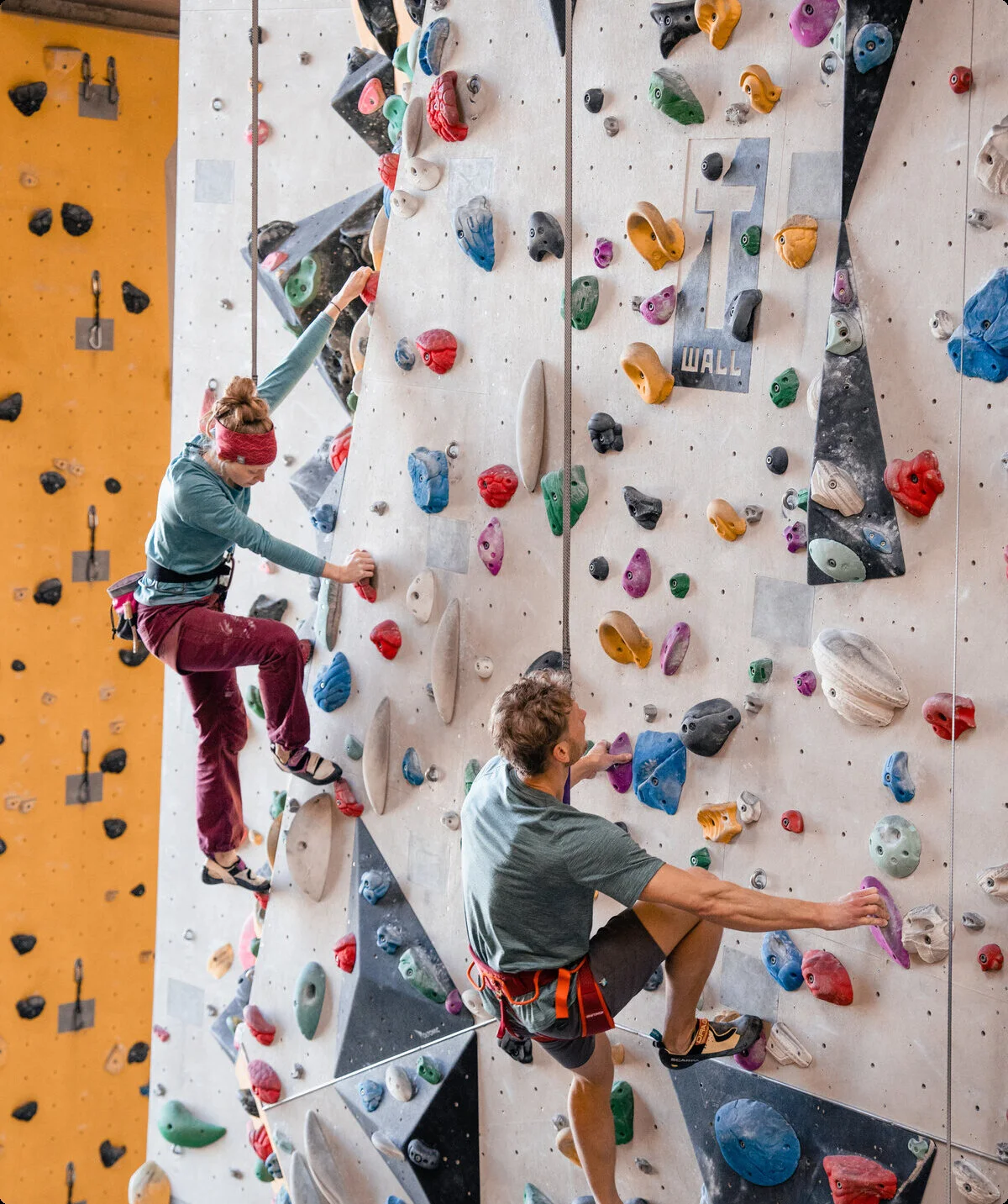 Zwei Personen bouldern nebeneinander an einer Boulderwand | © DAV/Marisa Koch
