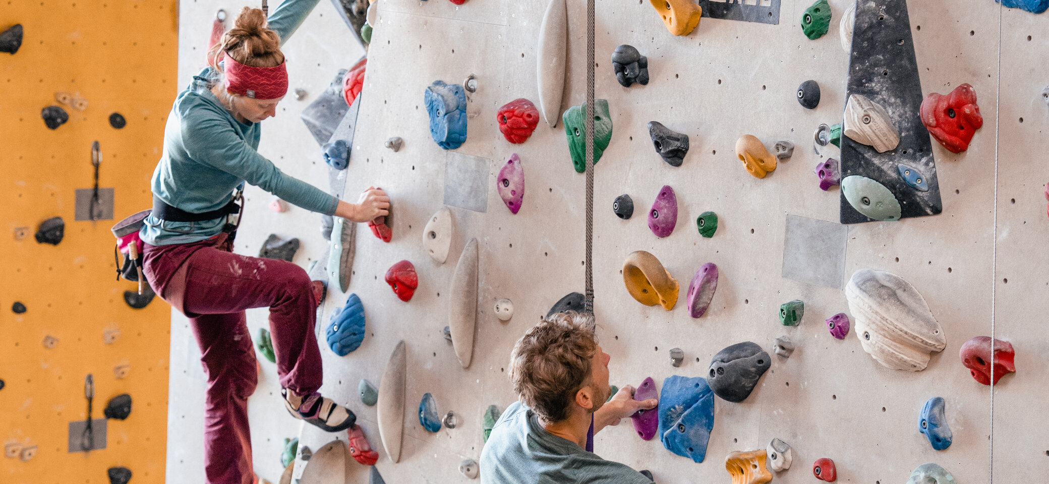 Zwei Personen bouldern nebeneinander an einer Boulderwand | © DAV/Marisa Koch