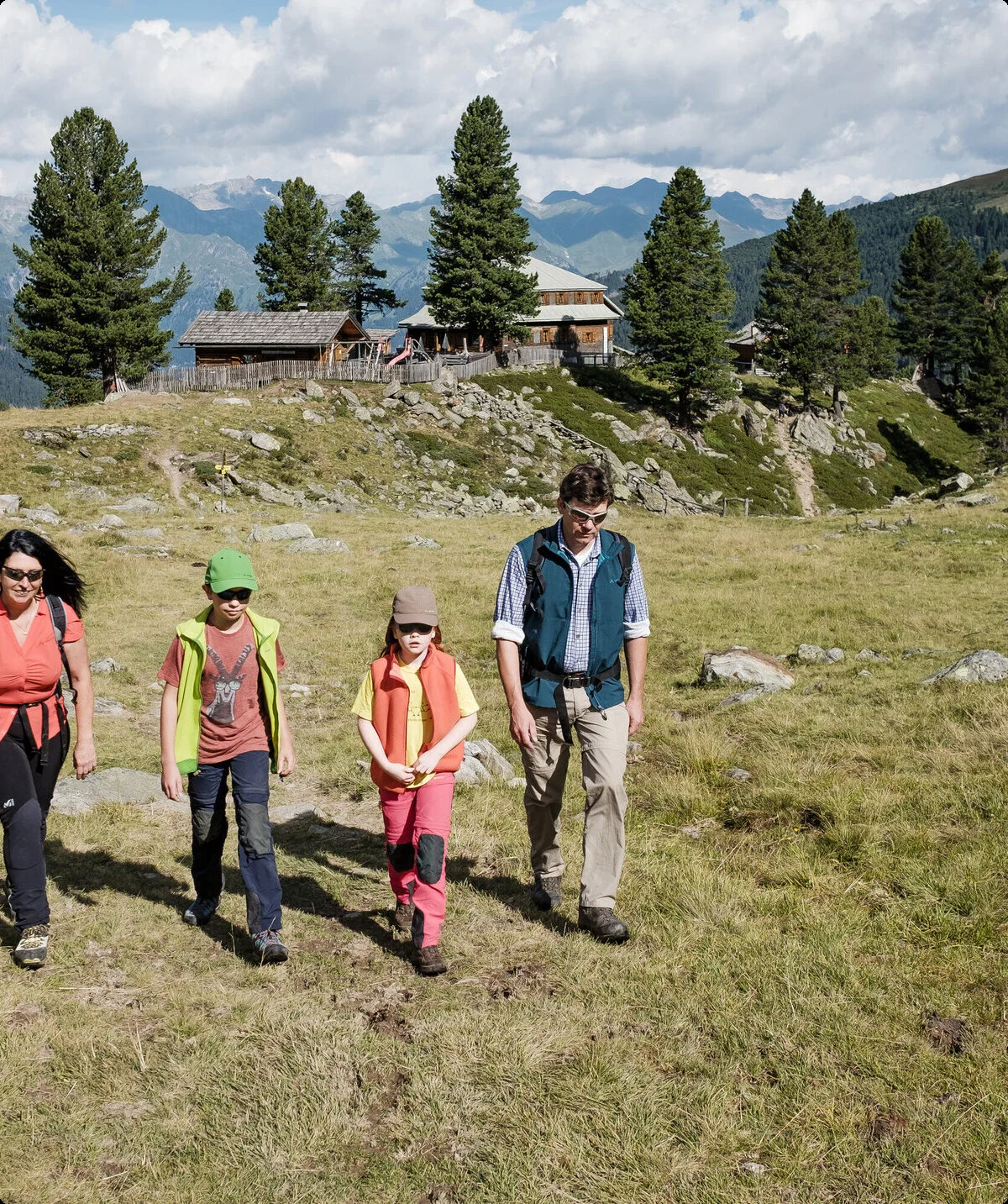 Eine Familie mit zwei kleinen Kindern wandert über eine Bergwiese | © DAV/Hans Herbig
