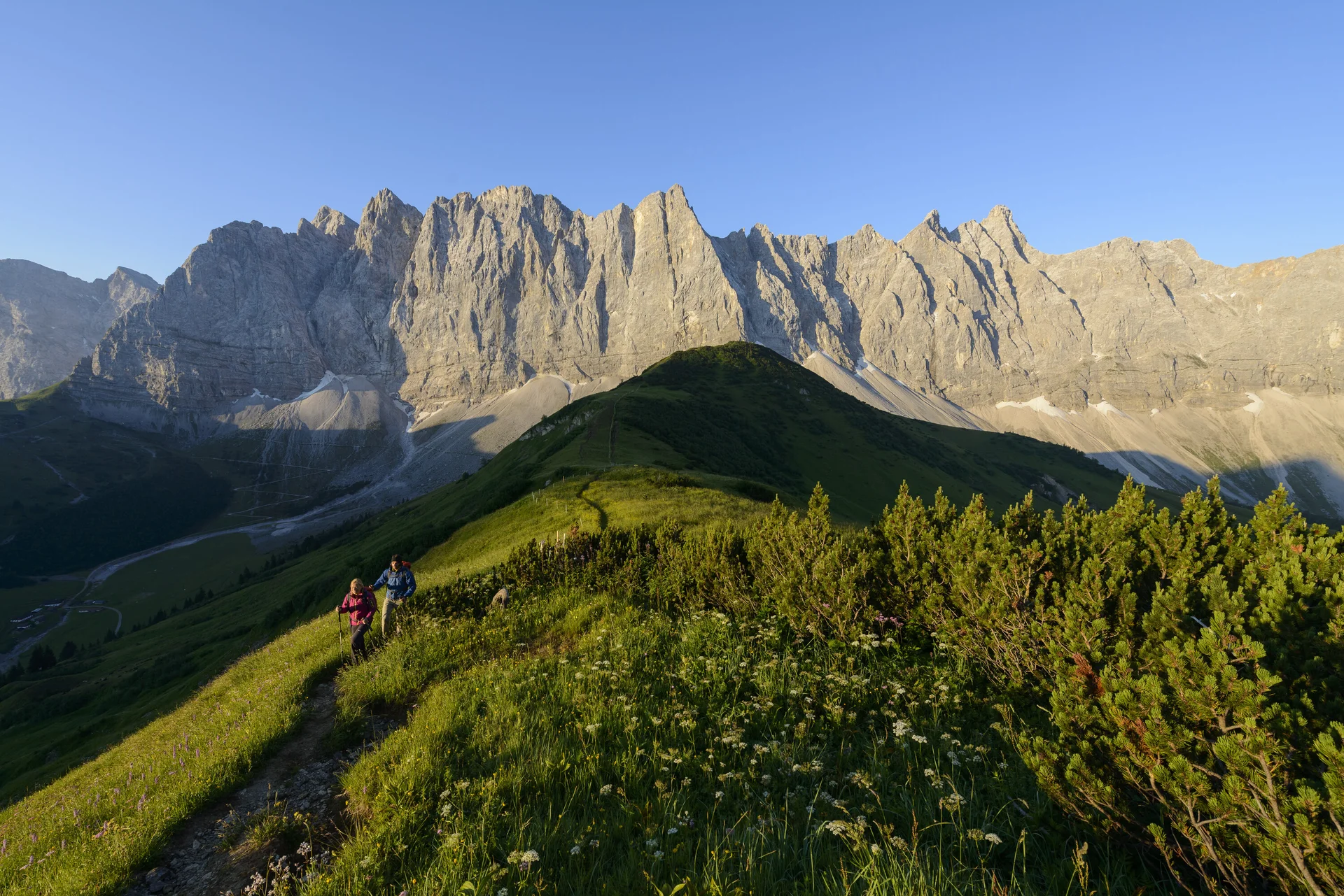 Panoramaaufname von Berggipfeln mit zwei Wanderern | © DAV/Wolfgang Ehn